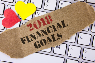 Conceptual hand writing showing 2018 Financial Goals. Business photo text New business strategy earn more profits less investment written Tear Cardboard Piece placed the Laptop Hearts.