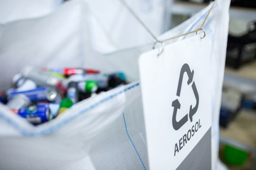 Sorting recyclables. The sorted aerosol aluminum cans, is placed in a container with the appropriate marking. - obrazy, fototapety, plakaty