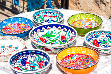 Colorful plates with bright patterns. Plates of orange, green, blue and white. Patterns in the form...