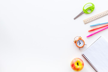 Education concept with stationery of student with notebook, pens, clock on white background top...