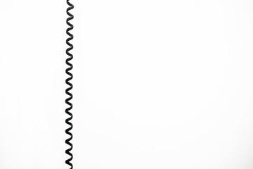 black vintage spring cable (wire) on white background verticaly 
