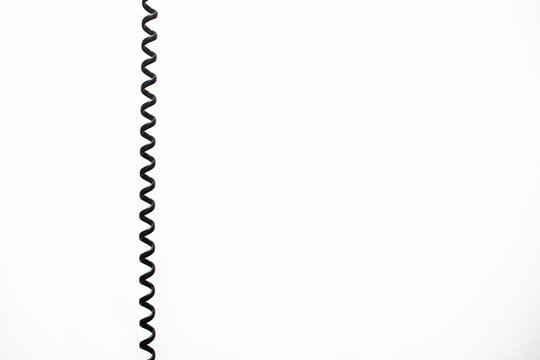 black vintage spring cable (wire) on white background verticaly 