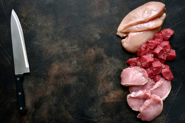 Assortment of raw fresh white and red meat : chicken breast, beef and pork fillet.Top view with copy space.