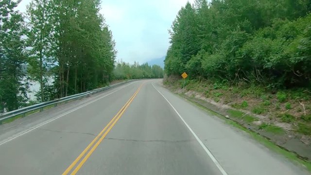 POV through front windshield while driving on the Sterling Highway in Alaska; visible are smoke from local wildfire, Kenai River, Chugach National Forest and Kenai Mountains