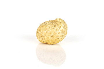 One whole small natural yellow peanut in closeup isolated on white background