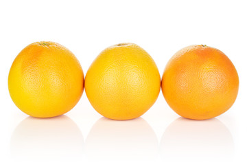 Group of three whole fresh pink grapefruit in row isolated on white background