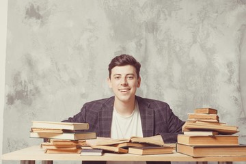 Young boy student sitting near the table with books in glasses. happy guy want learning, have education. online education. Study in school. Male happy. Electronic library, e-book concept