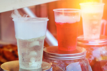 Soft drinks in the summer cafe. Cold soda sold on a hot day outdoors. Juices of bright colors with ice cubes.