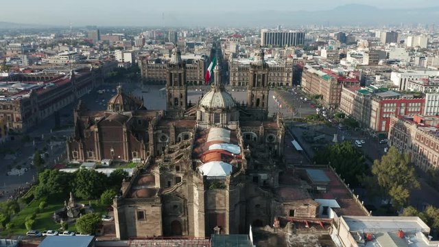 day flying over National Cathedral towards flag at center of Mexico City's Zocalo