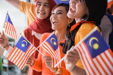 malaysia people holding flag celebrating independence day together