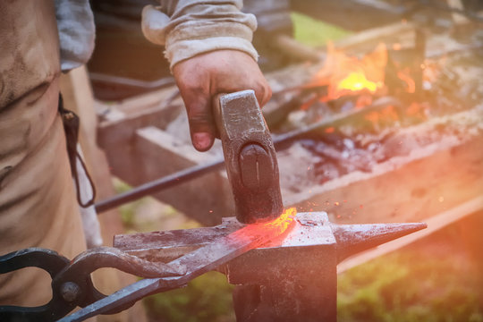 The blacksmith strikes the red blade of the sword with a hammer. Work in the forge to create weapons. The knife is between a rock and a hard place. - Powered by Adobe