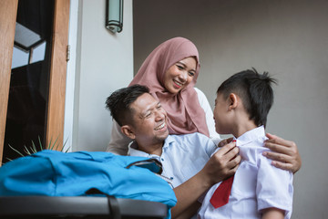 Obraz premium beautiful indonesia family with kid wearing school uniform back to school