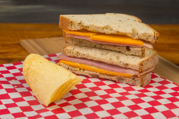 Ham and Cheese on Rye Bread with Chips in Fast Food Restaurant Setting