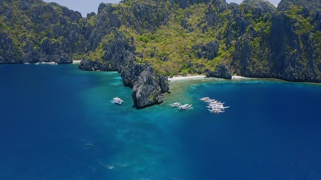 Aerial circle view of trip boats moored on diving spot near secret lagoon on Miniloc Island. El-Nido, Palawan. Philippines