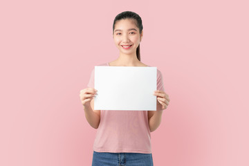 Fototapeta na wymiar Young Asian woman holding blank paper with smiling face and looking on the blue background. for advertising signs.