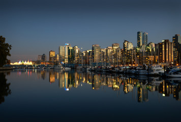 Naklejka premium Coal Harbor Skyline Twilight Reflections. A calm Coal Harbor next to Stanley Park at twilight. Vancouver, British Columbia.
