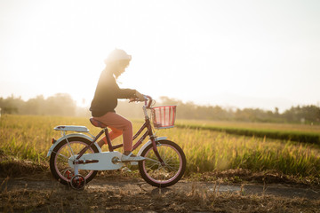 toddler enjoy riding her bicycle outdoor in beautiful day