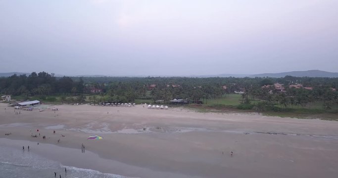 A Drone shot over a beautiful sea heading towards the trees, Goa, India.