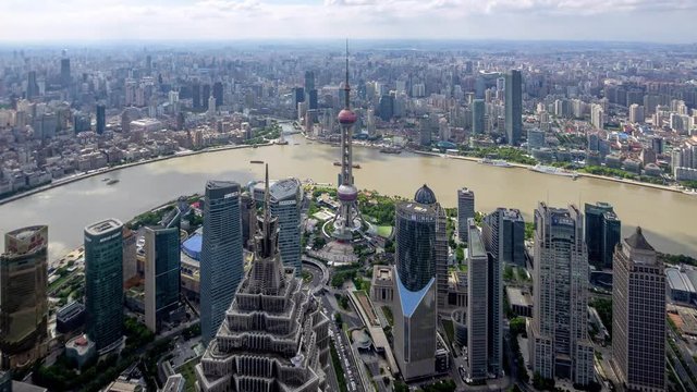 Time lapse of shanghai bund, modern city in cloudy afternoon, aerial view of bund skyline, ships sailing on huangpu river and busy traffic on road, 4k Version.