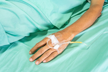 Close up image of IV drip in patient's hand in hospital.