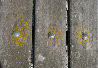 three wooden shelves where three metal pins are beaten through