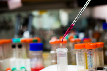 laboratory equipment pipette dropping sample into a test tube,abstract science background.