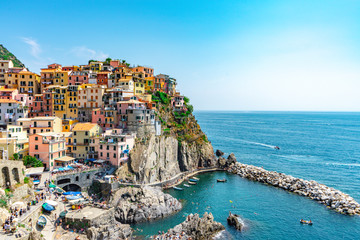 Fototapeta na wymiar Amazing view of Manarola village in Cinque Terre, Italy. Sunny day and blue sky of an afternoon in the European summer. Unesco World Heritage Site