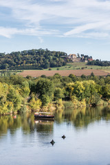 Old boat sails along Dordogne River in late afternoon light