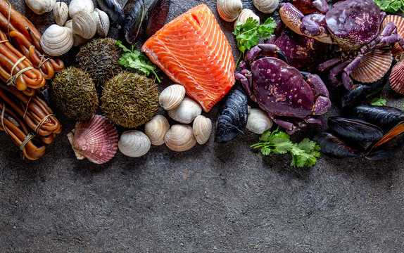 PACIFIC SEAFOOD. Fresh salmon, crabs ostions clams mussels, seaweed cochayuyo, sea urchins. Food background with copy space