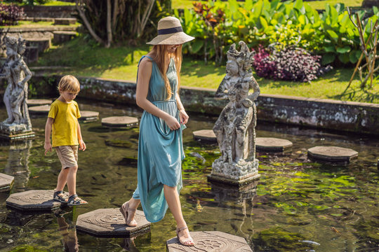 Mom and son tourists in Taman Tirtagangga, Water palace, Water park, Bali Indonesia. Traveling with children concept. Kids friendly place