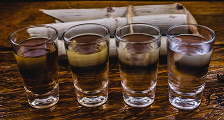 Cachaça, drip, cane or sugarcane is the name given to sugarcane brandy produced in Brazil. Traditional alcoholic drink from Brazil with sugar cane in the background.