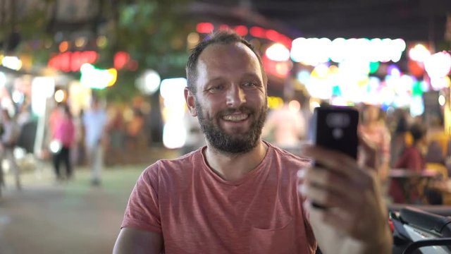 Young man taking selfie with cellphone in bar