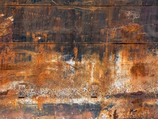 multi colored dry rusty metal wall with orange and black