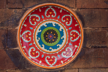 Balinese decoration, painted plate on a stone wall