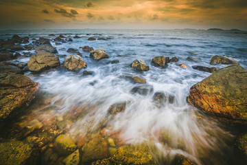 Obraz premium Sunset seascape with rocky beach and crashing waves, Rocks and stone in the sea with wave on sunset time, Nature landscape -Image