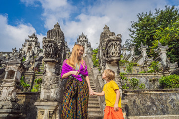 Mother and son tourists on background of Three stone ladders in beautiful Pura Lempuyang Luhur temple. Summer landscape with stairs to temple. Paduraksa portals marking entrance to middle sanctum jaba
