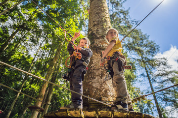 Two little boys in a rope park. Active physical recreation of the child in the fresh air in the park. Training for children