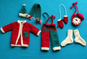 Santa clothes, gloves, hat, scarf, socks on blue background for Christmas