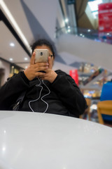 The girl sat on the chair with a happy mobile phone.