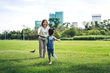 Portrait of happy grandmother and little cute girl enjoy relax together in summer park,little girl...