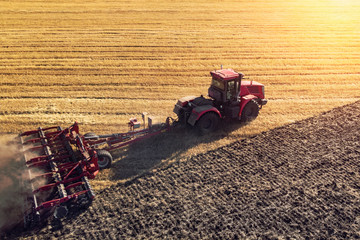 Agriculture machine harvesting crop in fields. Tractor pulls a mechanism for haymaking. Harvesting in autumn in the morning at dawn. agribusiness in the Altai region Russia.