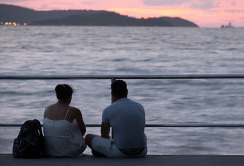 couple relax in front of the sea with sunset view.