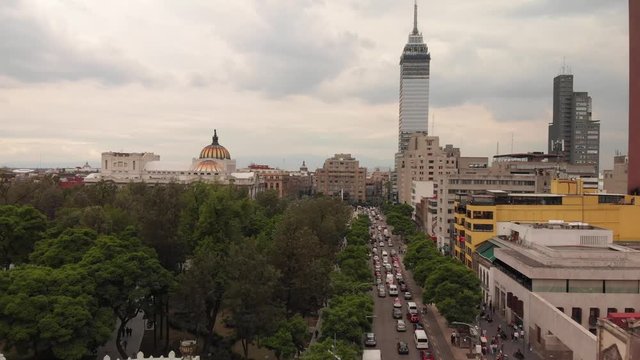 Aerial view of the traffic in Av. Ju&aacute;rez in M&eacute;xico City during rush hour. Drone flying forward above the cars with the city skyline as background.