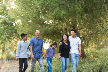 Happy Asian family walking and talking outside.