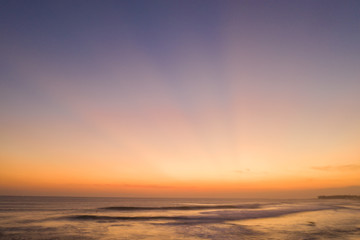 Fototapeta premium Aerial drone view of the sea over beautiful golden sunset sky background