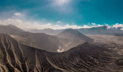 Cinematic shot aerial view of Mount Bromo crater with active volcano smoke in East Java, Indonesia