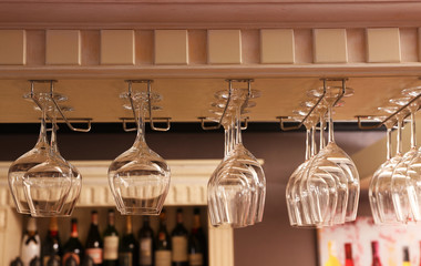 Set of empty clean glasses on bar racks