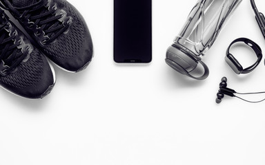 Fit health lifestyle and weight lose diet background concept. Fitness equipment running shoes,water bottle, smartwatch,smartphone, earphone on white.