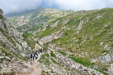 Obraz premium Rear view of mature and senior people hiking in Brenta Dolomites, Italy
