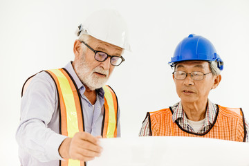 two senior professional architecture engineer consulting with builder foreman for safty and fast building home in construction site looking at blueprint